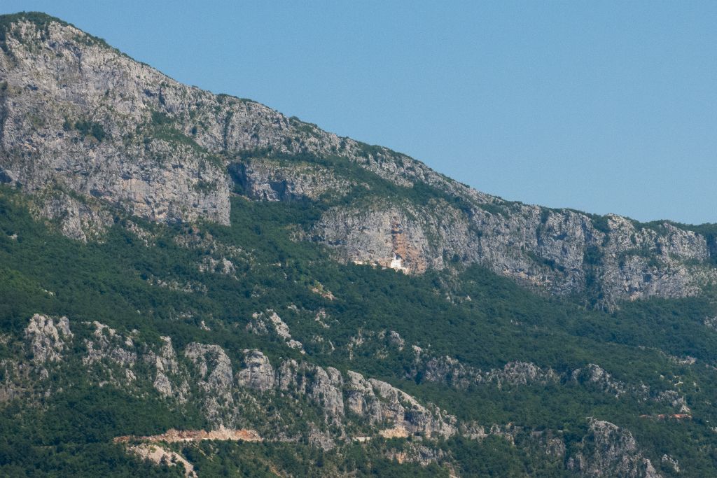 De loin, on peut apercevoir le monastère d'Ostrog encastré dans une falaise qui domine la vallée de Zeta